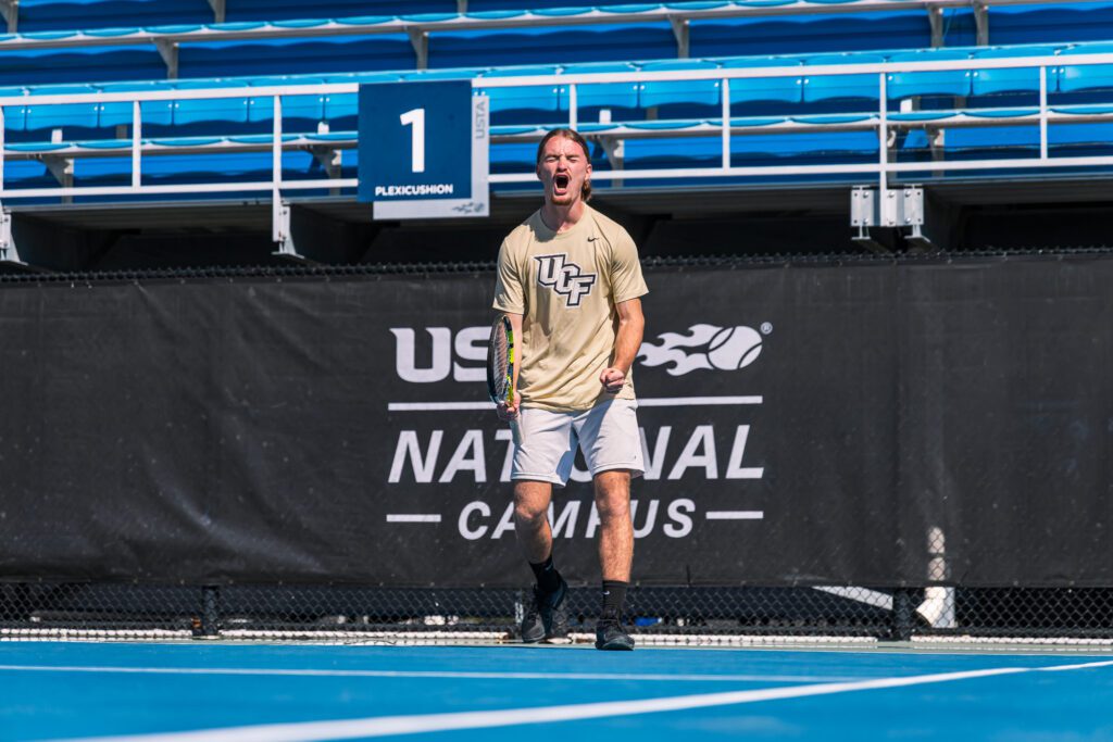 UCF tennis player celebrating a point on a court at the USTA National Campus in Florida
