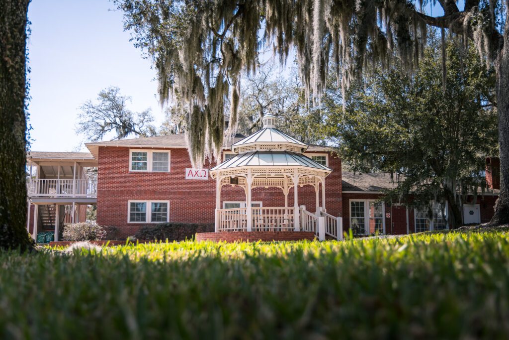 Brick university building and gazebo surrounded by large trees in Florida