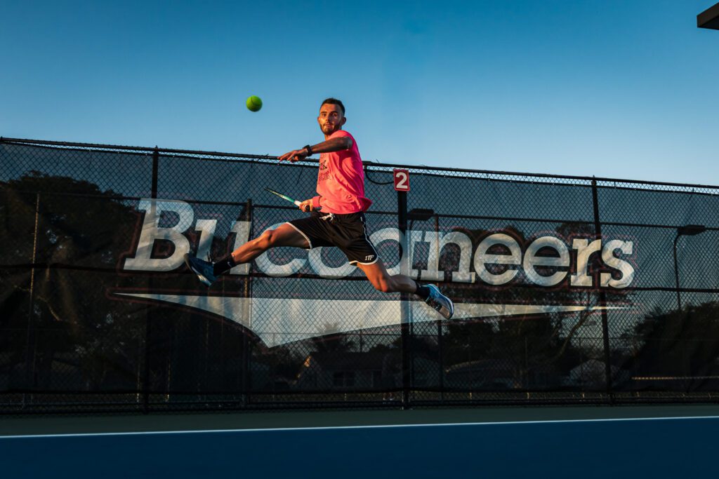 Player hitting a ball in mid-air on the courts of Barry University in Florida